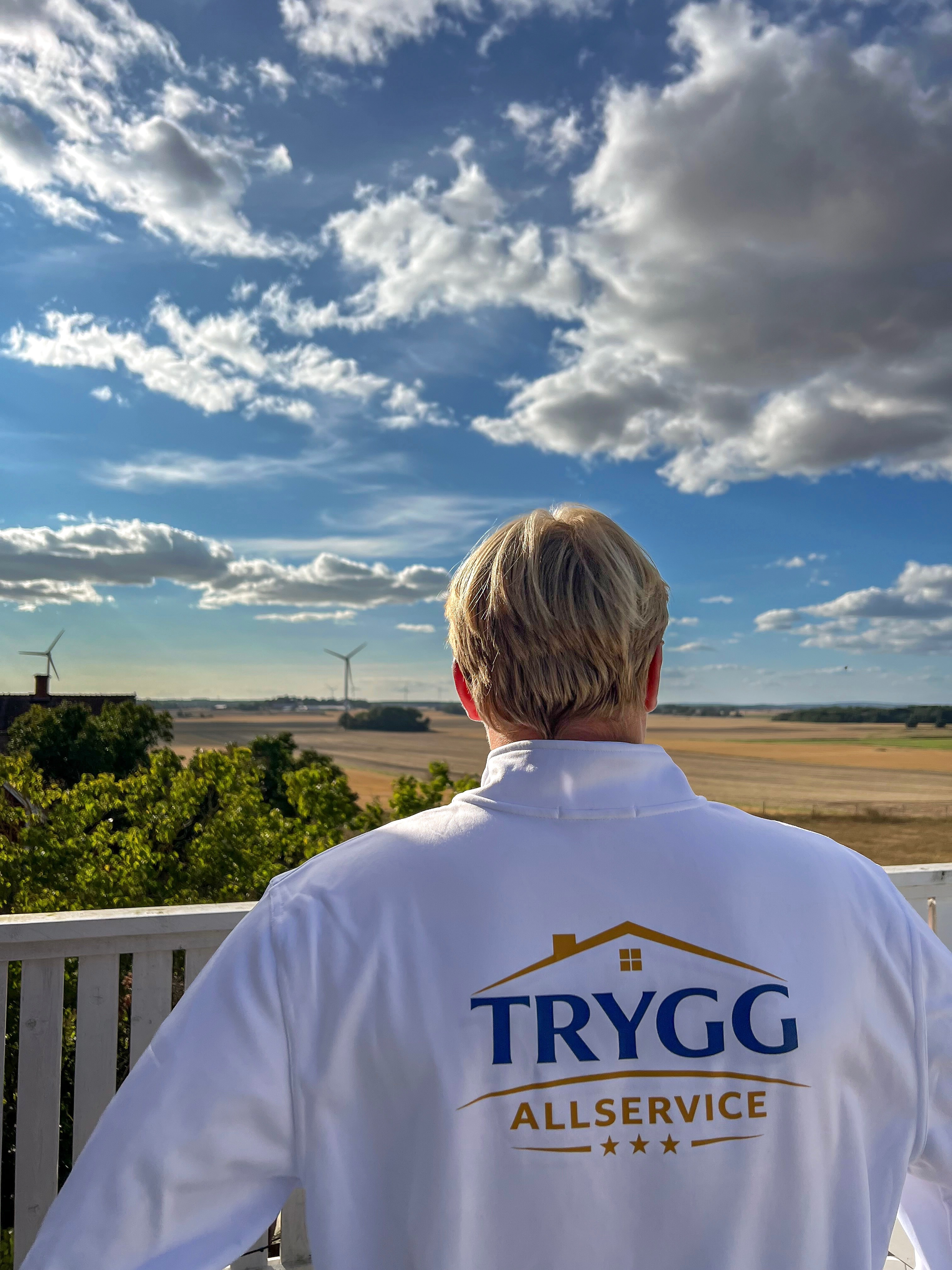 Trygg Allservice-tröja med utsikt över Östergötlands landskap